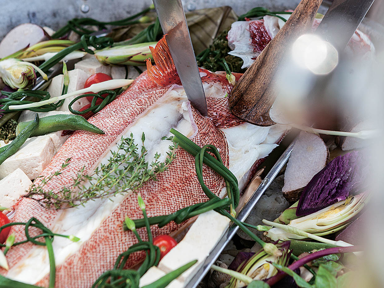 アカジンを料理。鍋の下にはサンゴを敷き、海水を少し入れ、白ワインで魚や島野菜を蒸す。サンゴで蒸すと磯の香りが立つ。